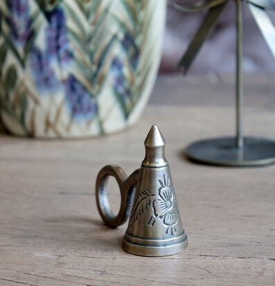 Bild av antik ljussläckare i mässing på träbord med mönster