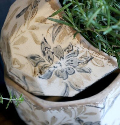 Bild på mönstrade keramikkrukor med växt i rustik inredning