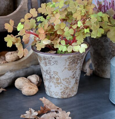 Bild av keramikkruka med blommönster och gröna växter i harmoni