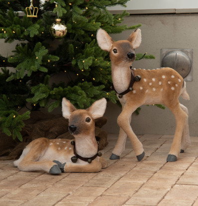 Bild på dekorativa dovhjortar och julgran i naturnära miljö