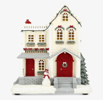 Bild av vintrigt miniatyrhus med juldekoration och snögubbe