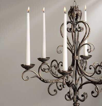 Bild av konstfull ljuskrona med tända ljus och antik finish