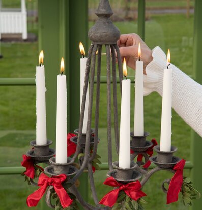 Bild av rustik ljuskrona med tända ljus och gröna detaljer