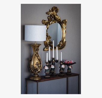 Bild på elegant sidobord med spegel, lampa och tomteljusstakar