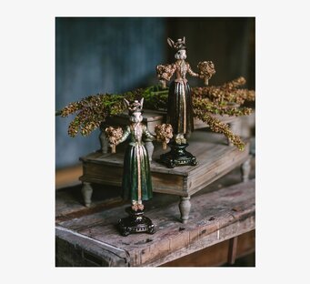 Bild av piedestalbord med dekorativa harfigurer och blommor