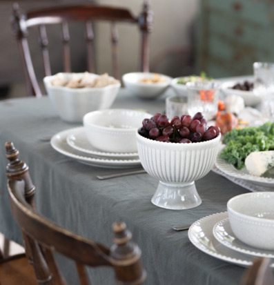 Bild av dukat matbord med vit servis och eleganta detaljer