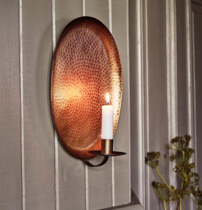 Bild på elegant väggljusstake i antik mässing mot träpanel