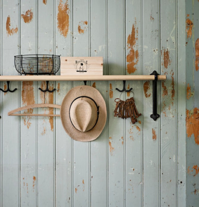 Bild av hylla på nött panelvägg med krokar och vardagsföremål