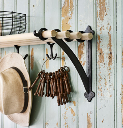 Bild på hylla med krokar mot grön patinerad trävägg