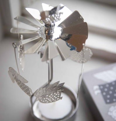 Bild på klassiskt änglaspel i metall på ljus fönsterbräda