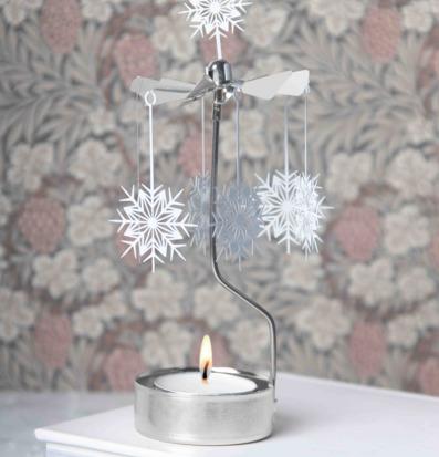 Bild på dekorativt änglaspel med vita snöstjärnor och ljus