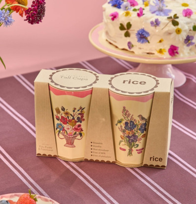 Bild av färgstark dukning med blommiga muggar och fika