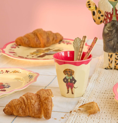 Bild av lekfull dukning med färgglada muggar och tallrikar