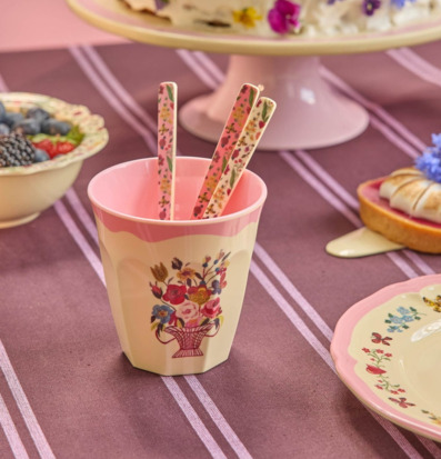 Bild på pastellfärgad bordsdukning med blommiga detaljer