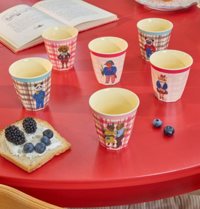 Bild av färgglad barndukning med muggar, frukt och bok