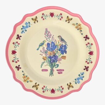 Bild av rund tallrik med neonrosa kant och blomsterdekor