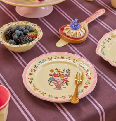 Bild av pastellfärgad dukning med blommig assiett och tårta