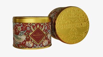 Bild på rund plåtburk med dekorerat lock och röda motiv