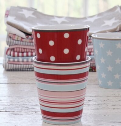 Bild av färgrika muggar och textilier i hemtrevlig miljö