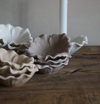 Foto: Blomformade keramikskålar och tänt ljus i ro﻿