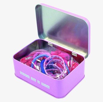 Bild av lila plåtburk med färgglada håraccessoarer