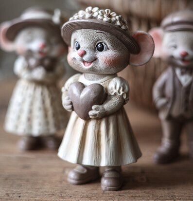 Foto på musfigur med hatt och hjärta på träbordet