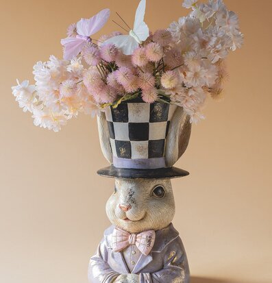Foto på kaninbyst med rutmönstrad hatt och blommor