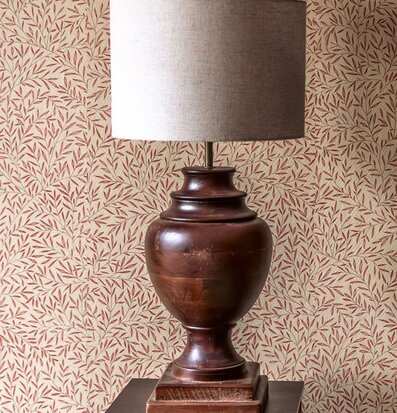 Foto av brun bordslampa mot mönstrad tapet inomhus