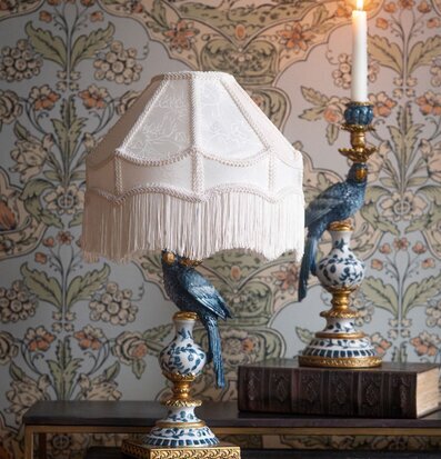 Foto: Blåvit ljusstake med papegojor och tänt ljus