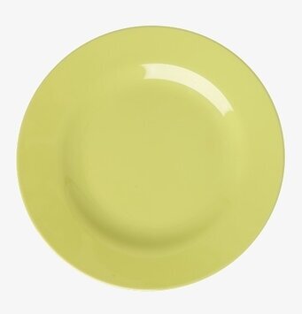 Foto på ljusgul rund assiett på vit bakgrund, ovanifrån