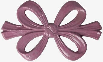 Foto: Lila grytunderlägg i rosettform på vit bakgrund