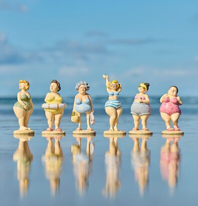 Bild: Strandfigurer på rad med spegling vid havet