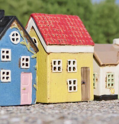 Foto: Tre husformade ljuslyktor i soligt uteljus