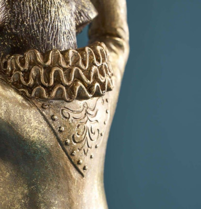 Foto: Detalj av metallfigur med krage och ornament