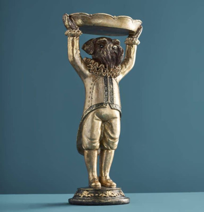 Foto: Hundstaty med fat på piedestal mot blå bakgrund