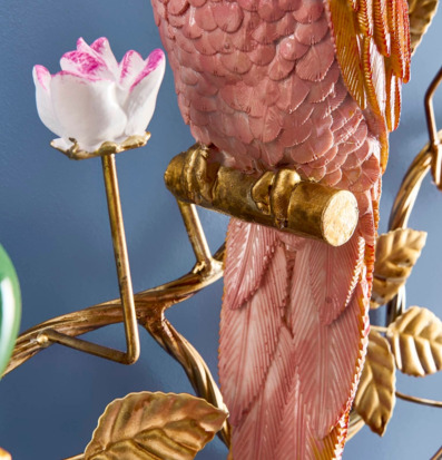Foto på väggljusstake med papegoja i rosa och guld