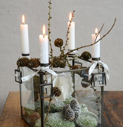 Bild av ljusstake med glasbox och naturligt arrangemang