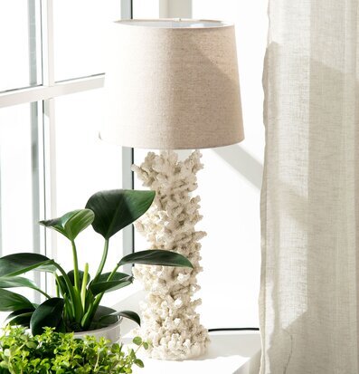 Bild av korallformad lampfot i fönster med växter