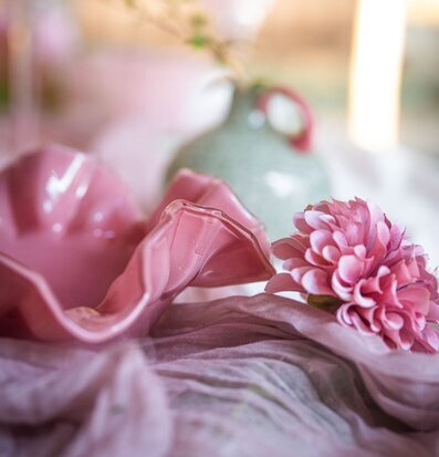 Foto: Rosa blomformad skål med blomma och vas i tyg