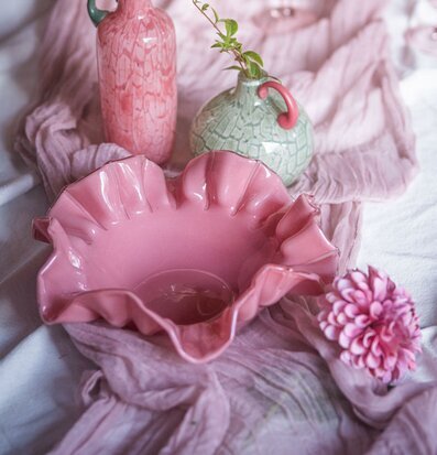 Foto: Rosa blomformad skål i stilleben med vaser