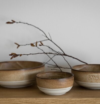 Foto: Tre bruna keramiska skålar på träbord, kvist
