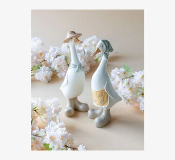 Foto av två dekorationsankor med vårblommor i studio