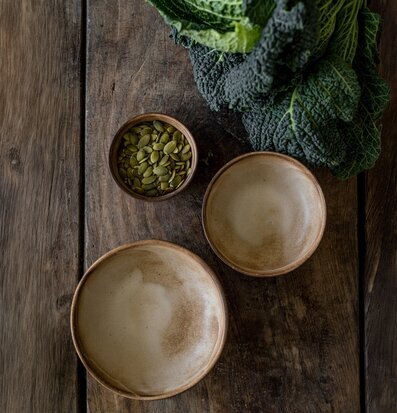 Foto: Rustika keramiska skålar på träbord, grönkål