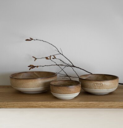Foto: Tre bruna keramikskålar på träyta, stilrent