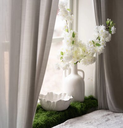 Foto: Vit skål och vas med vita blommor vid fönster