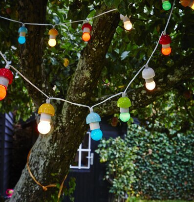 Bild av ljusslinga i trädgård för en festlig atmosfär