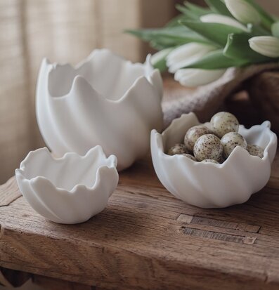 Bild: Keramiska äggskalsskålar på träbord, vårtema