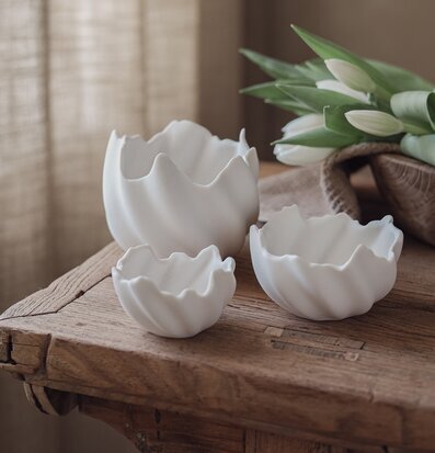 Foto: Vita äggskalsformade skålar på träbordet