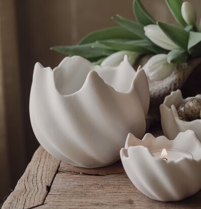 Bild: Vita keramikskal, värmeljus och tulpaner i trä