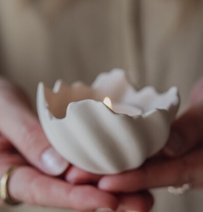 Foto: Skålformad ljushållare i händer med ljus